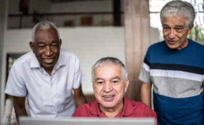 three senior friends at laptop
